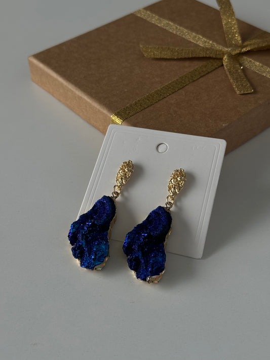 Bold and elegant, these earrings feature richly textured stones in a metallic deep blue tone
